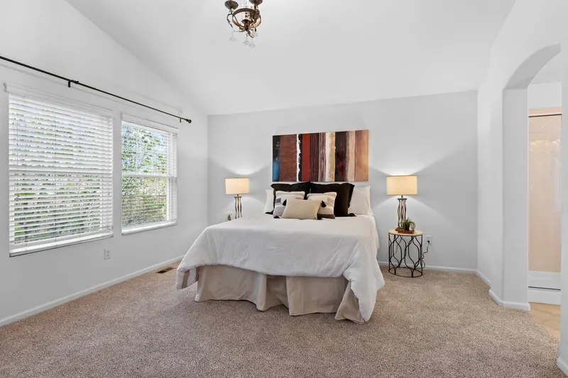 Same primary bedroom after new carpet, paint, and staging