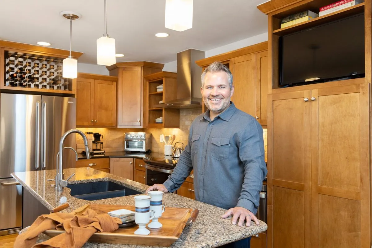 Jacob Stark reviewing a home with clients in a modern kitchen in Denver, Colorado